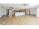 Bright living area showcasing wood-look floors, a ceiling fan, and easy access to the kitchen and outdoor patio at 1760 Sharondale Dr, Clearwater, FL 33755