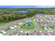 An aerial view showcases a community playground surrounded by nature with many homes and a lake nearby at 20659 Drake Elm Dr, Land O Lakes, FL 34638
