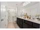 Bright bathroom featuring double sinks, a large mirror, and a glass-enclosed shower at 20659 Drake Elm Dr, Land O Lakes, FL 34638