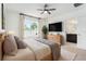 Bright bedroom features a ceiling fan, large window, mounted TV, and en-suite bathroom at 20659 Drake Elm Dr, Land O Lakes, FL 34638