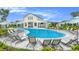 Community pool with lounge chairs, umbrellas and clubhouse is an oasis for relaxing and enjoying the outdoors at 20659 Drake Elm Dr, Land O Lakes, FL 34638