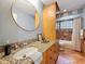 Bathroom featuring wood cabinets, a large mirror, and a walk-in shower with tile surround at 213 Sheffield E Cir, Palm Harbor, FL 34683