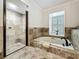 Bathroom featuring a walk-in shower, soaking tub, and shuttered window for natural light at 213 Sheffield E Cir, Palm Harbor, FL 34683