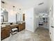 Spacious bathroom featuring dual vanities, decorative mirrors, and elegant tile flooring at 213 Sheffield E Cir, Palm Harbor, FL 34683