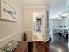 Hallway leading to a bedroom and bathroom, showcasing hardwood floors and decorative artwork at 213 Sheffield E Cir, Palm Harbor, FL 34683
