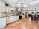 Bright kitchen featuring stainless steel appliances, tile backsplash, white cabinets, granite countertops, and tile flooring at 213 Sheffield E Cir, Palm Harbor, FL 34683