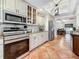 Well-equipped kitchen with stainless steel appliances, white cabinets, granite countertops, and tile flooring at 213 Sheffield E Cir, Palm Harbor, FL 34683