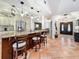 Open-concept kitchen with an island with seating, granite countertops, stainless steel appliances and view of the foyer at 213 Sheffield E Cir, Palm Harbor, FL 34683