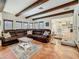 Spacious living room features exposed wood beams, tile floors, and opens to the kitchen for easy entertaining at 213 Sheffield E Cir, Palm Harbor, FL 34683