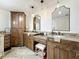 Elegant main bathroom features dual vanities, granite countertops, custom cabinetry, and stylish lighting at 213 Sheffield E Cir, Palm Harbor, FL 34683