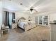 Bright main bedroom with plush carpet flooring, ceiling fan, and French doors leading to a custom closet at 213 Sheffield E Cir, Palm Harbor, FL 34683