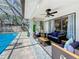 Screened in pool with cozy seating and ceiling fan, perfect for relaxation and outdoor enjoyment at 213 Sheffield E Cir, Palm Harbor, FL 34683
