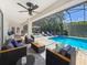 Inviting screened in pool with cozy seating and ceiling fan, perfect for outdoor entertaining and relaxation at 213 Sheffield E Cir, Palm Harbor, FL 34683