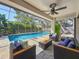 Screened in pool with cozy seating and ceiling fan, perfect for relaxation and outdoor enjoyment at 213 Sheffield E Cir, Palm Harbor, FL 34683