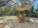Relaxing screened patio featuring a table with umbrella, and a view of the backyard at 213 Sheffield E Cir, Palm Harbor, FL 34683