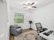 Cozy bedroom with ceiling fan, chair, and a window allowing ample natural light at 232 Emerald Ln, Largo, FL 33771