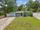 Charming single-story home featuring a well-maintained lawn and tasteful landscaping with vibrant palm trees at 232 Emerald Ln, Largo, FL 33771