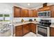Kitchen with wood cabinets, granite counters and stainless appliances, adjacent to breakfast area at 232 Emerald Ln, Largo, FL 33771