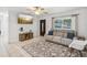 Bright living room featuring a comfortable couch, a stylish rug and a mounted television at 232 Emerald Ln, Largo, FL 33771
