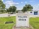 Village Green sign with the community name displayed at 232 Emerald Ln, Largo, FL 33771