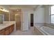Bright bathroom featuring double sinks, a glass shower, and a relaxing soaking tub at 2515 Centennial Falcon Dr, Valrico, FL 33596