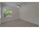 Bright bedroom with white walls, neutral carpet, ceiling fan, and shuttered window at 2515 Centennial Falcon Dr, Valrico, FL 33596