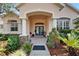 Welcoming front entrance with a blue double door, stone accents, and lush greenery at 2515 Centennial Falcon Dr, Valrico, FL 33596