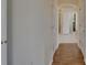 Hallway featuring wood floors transitioning into tile and access to a bathroom at 2515 Centennial Falcon Dr, Valrico, FL 33596