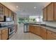 Spacious kitchen featuring wooden cabinets, tile flooring, and a stainless steel appliance package at 2515 Centennial Falcon Dr, Valrico, FL 33596