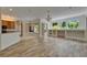 Bright living room featuring wood-look floors and access to dining and kitchen areas, great for entertaining at 2515 Centennial Falcon Dr, Valrico, FL 33596