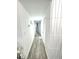 Hallway featuring modern paneled wall, light paint, and wood-look flooring, creating a clean aesthetic at 2525 W Bay Dr # A20, Belleair Bluffs, FL 33770
