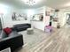 Open living space features sleek black sofas, stylish ottoman, and views of the kitchen and dining area at 2525 W Bay Dr # A20, Belleair Bluffs, FL 33770