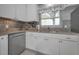 Kitchen featuring stainless steel dishwasher, granite countertops, and tiled backsplash at 2700 Bayshore Blvd # 547, Dunedin, FL 34698