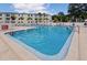 A refreshing outdoor pool with swimmers, lounge chairs, and well-maintained surroundings at 2700 Bayshore Blvd # 547, Dunedin, FL 34698