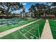 Well-maintained shuffleboard courts in a landscaped community with trees in the background at 2700 Bayshore Blvd # 547, Dunedin, FL 34698
