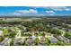This aerial view features a home in a neighborhood near a lake surrounded by lush greenery and agricultural fields at 3004 Spring Hammock Dr, Plant City, FL 33566