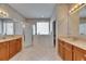 Bathroom features a walk-in shower, walk-in tub, tile floors, and dual sink vanities with wood cabinetry at 3004 Spring Hammock Dr, Plant City, FL 33566