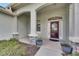 Covered front porch area featuring stone accents, decorative plants, and an elegant front door at 3004 Spring Hammock Dr, Plant City, FL 33566
