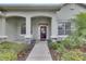 Inviting front porch with decorative columns, potted plants, and a stylish front door at 3004 Spring Hammock Dr, Plant City, FL 33566