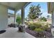 Covered front porch with stone-based columns, potted plants and a view of the landscaped front yard at 3004 Spring Hammock Dr, Plant City, FL 33566