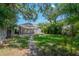 Backyard featuring grass, shade, tropical landscaping, and a brick-paver patio at 302 W Hilda St, Tampa, FL 33603