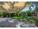 Backyard featuring a shade structure, manicured lawn, brick patio and lush greenery at 302 W Hilda St, Tampa, FL 33603