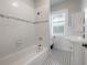 Bathroom featuring white subway tile, black and white mosaic flooring, and a window at 302 W Hilda St, Tampa, FL 33603