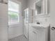 Bright bathroom featuring a vanity with storage, hexagon tile floor, and a window at 302 W Hilda St, Tampa, FL 33603