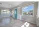 Bright sunroom with tile flooring, large windows, and a charming blue front door at 302 W Hilda St, Tampa, FL 33603