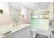 Well-lit bathroom featuring a shower with glass doors, and a vanity with traditional fixtures at 3087 Cherry Ln, Clearwater, FL 33759