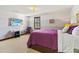 Cozy bedroom featuring a TV, window with wooden shutters, and comfortable chair at 3087 Cherry Ln, Clearwater, FL 33759
