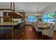Elegant dining area featuring hardwood floors, a large dining table, and views of a tropical scene on large displays at 3087 Cherry Ln, Clearwater, FL 33759