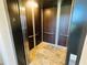 Interior view of the elevator with wood paneling and travertine floors at 3087 Cherry Ln, Clearwater, FL 33759