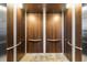 Interior of an elevator featuring wood paneling, stainless steel accents, and a tile floor at 3087 Cherry Ln, Clearwater, FL 33759